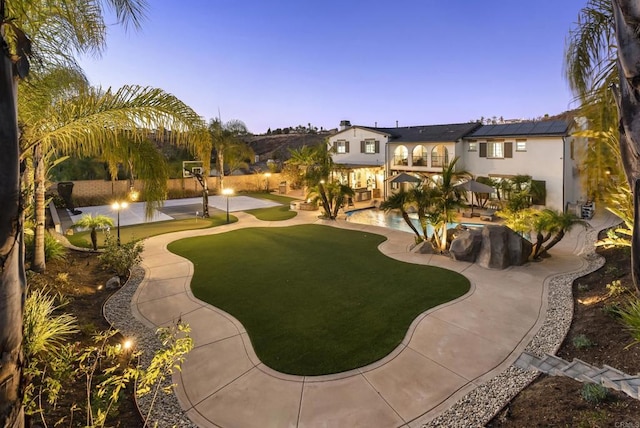 view of community featuring a swimming pool, a patio area, and a lawn