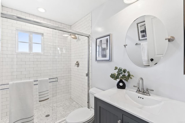 bathroom with vanity, toilet, and a shower with shower door