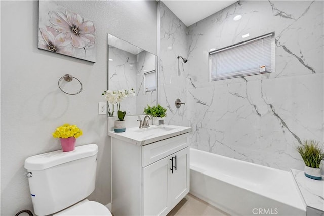 full bathroom featuring tiled shower / bath combo, vanity, and toilet