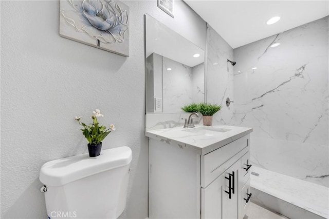 bathroom featuring toilet, vanity, and walk in shower