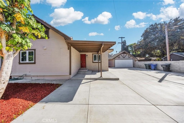 view of front of house featuring a garage and an outbuilding