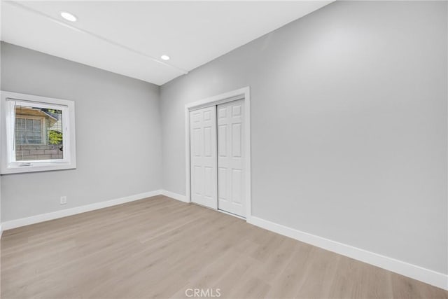 unfurnished bedroom featuring light wood-type flooring and a closet