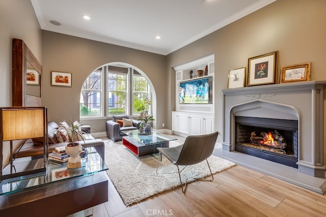 sitting room featuring crown molding, light hardwood / wood-style flooring, and built in shelves