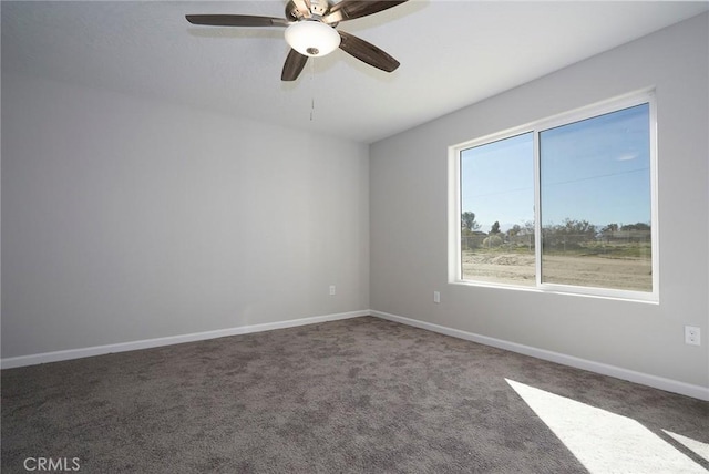 spare room featuring dark carpet and ceiling fan