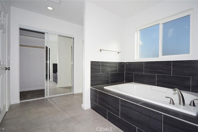 bathroom featuring tile patterned flooring and tiled tub