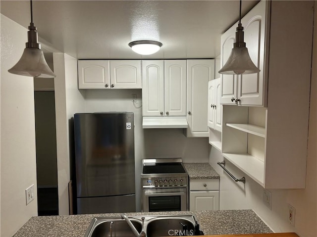 kitchen featuring decorative light fixtures, freestanding refrigerator, white cabinets, high end stove, and under cabinet range hood