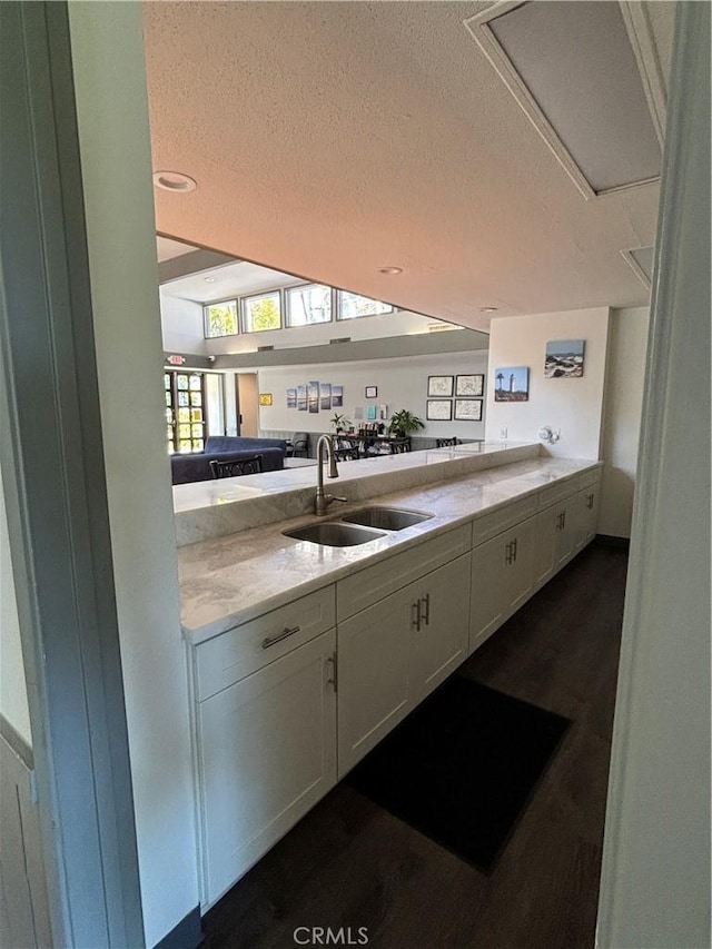 kitchen featuring white cabinetry, sink, kitchen peninsula, and a textured ceiling