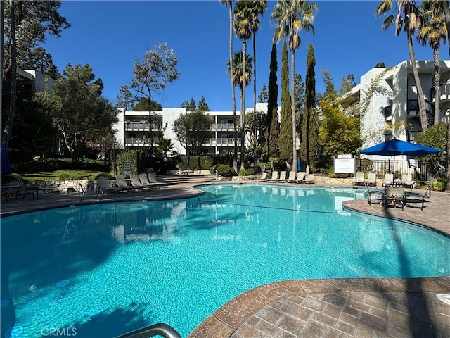 pool with a patio area and fence