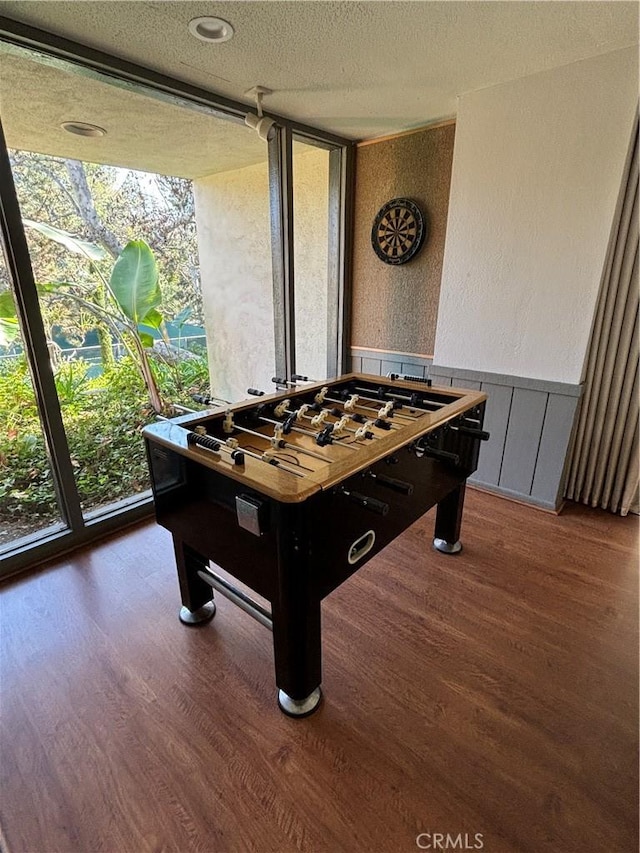 game room with dark hardwood / wood-style floors and a textured ceiling