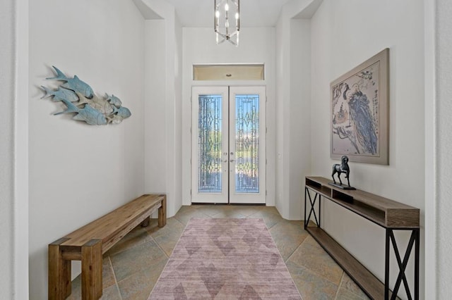 entrance foyer with an inviting chandelier and french doors