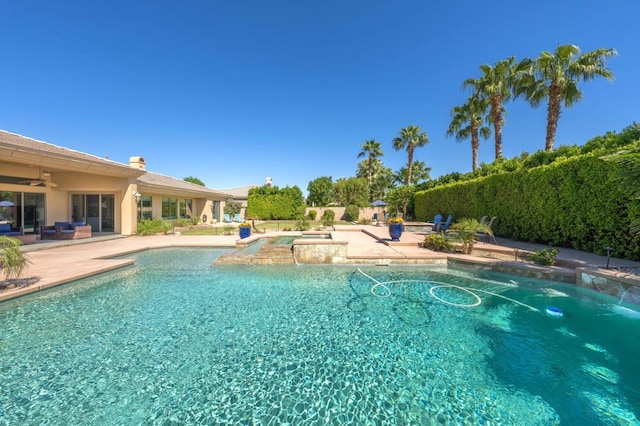 view of swimming pool featuring pool water feature, ceiling fan, and a patio area