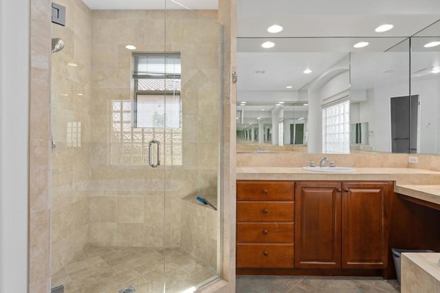 bathroom with a shower with door and vanity