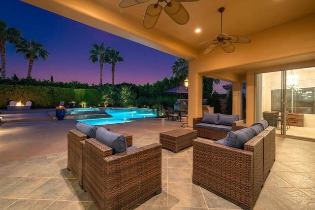 pool at dusk with ceiling fan, an outdoor hangout area, and a patio area