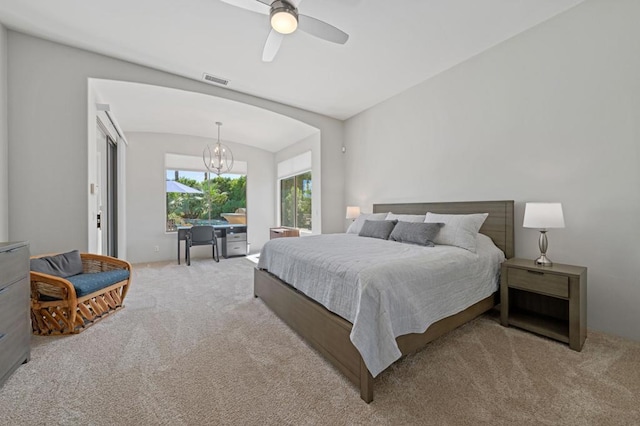 bedroom with ceiling fan with notable chandelier and light colored carpet