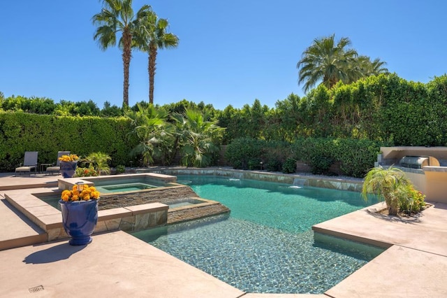 view of pool with a patio area and an in ground hot tub