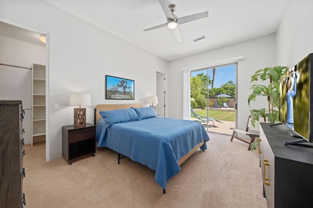 carpeted bedroom with a spacious closet, access to outside, and ceiling fan