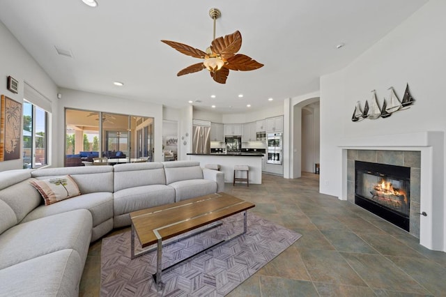 living room featuring a fireplace and ceiling fan