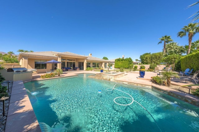 view of swimming pool featuring an in ground hot tub, pool water feature, and a patio area