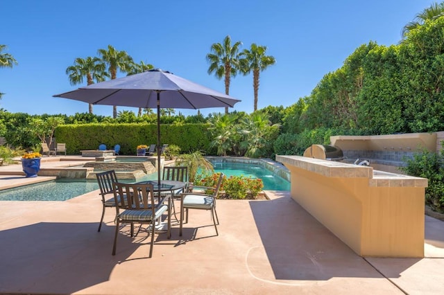 view of swimming pool with a patio area, exterior kitchen, and an in ground hot tub