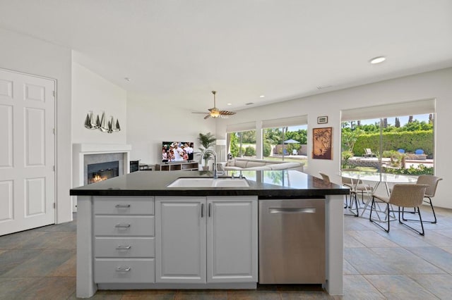 kitchen featuring white cabinetry, sink, stainless steel dishwasher, and an island with sink