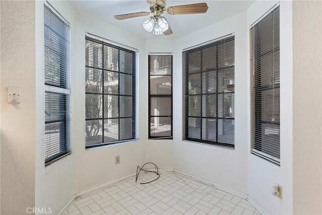 unfurnished room featuring ceiling fan and baseboards