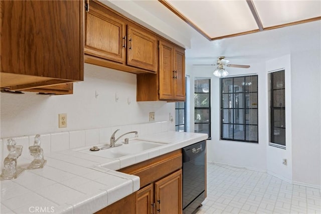 kitchen featuring tile counters, brown cabinets, dishwasher, and a sink