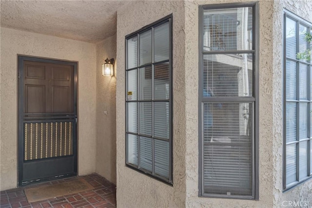 doorway to property featuring stucco siding