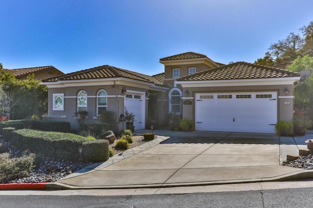 mediterranean / spanish-style house with a garage