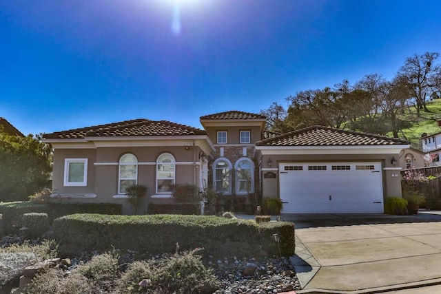 mediterranean / spanish home featuring a garage