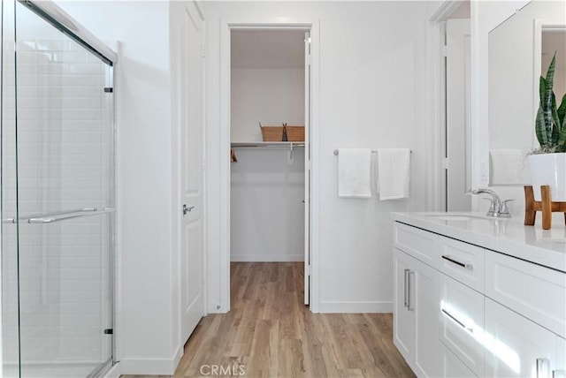 bathroom with vanity, hardwood / wood-style flooring, and a shower with door