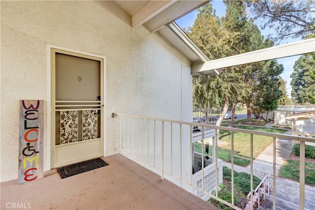 view of exterior entry with a balcony