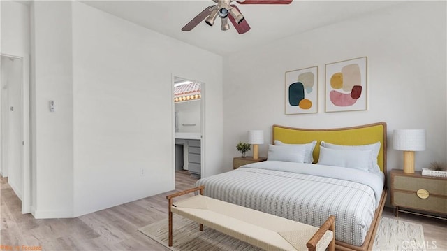 bedroom featuring light wood finished floors, a ceiling fan, and ensuite bathroom