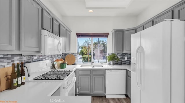 kitchen featuring white appliances, light countertops, and gray cabinetry