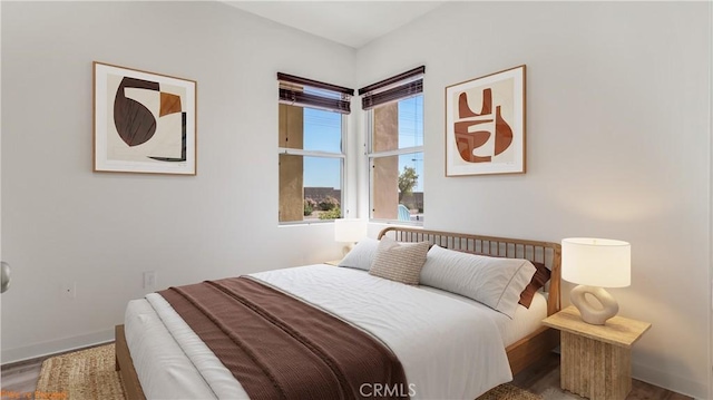 bedroom featuring baseboards and wood finished floors