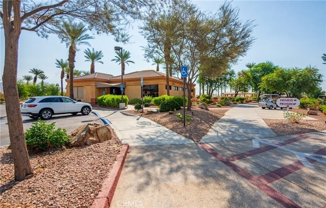 view of front of home featuring uncovered parking, a tile roof, and stucco siding