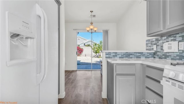 kitchen with decorative light fixtures, gray cabinets, light countertops, decorative backsplash, and white appliances