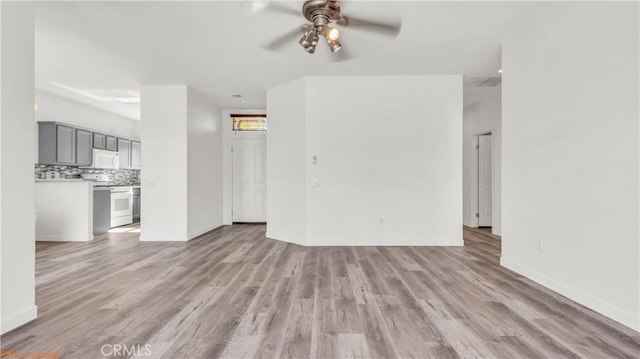 unfurnished living room featuring light wood finished floors, ceiling fan, and baseboards