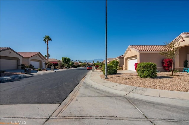 view of street featuring a residential view, curbs, and sidewalks