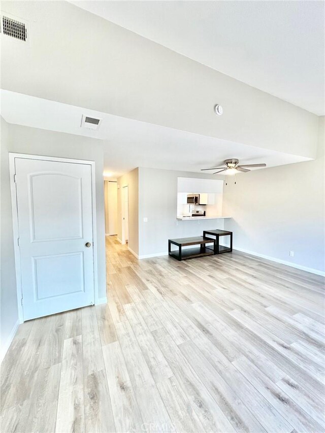 unfurnished living room featuring ceiling fan and light hardwood / wood-style flooring