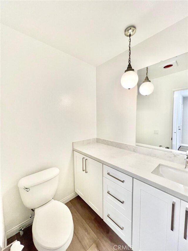 bathroom featuring vanity, toilet, and hardwood / wood-style floors