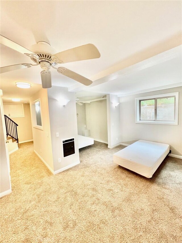 unfurnished bedroom featuring heating unit, ceiling fan, and light carpet