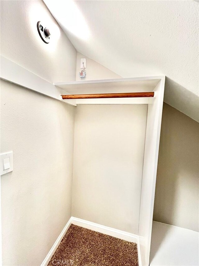 interior space featuring lofted ceiling and carpet