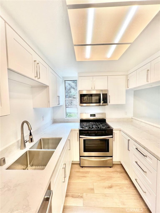 64 Avalon Terrace Rd, Avalon, CA 90704 - kitchen featuring white cabinetry, light wood-style flooring, appliances with stainless steel finishes, and a sink