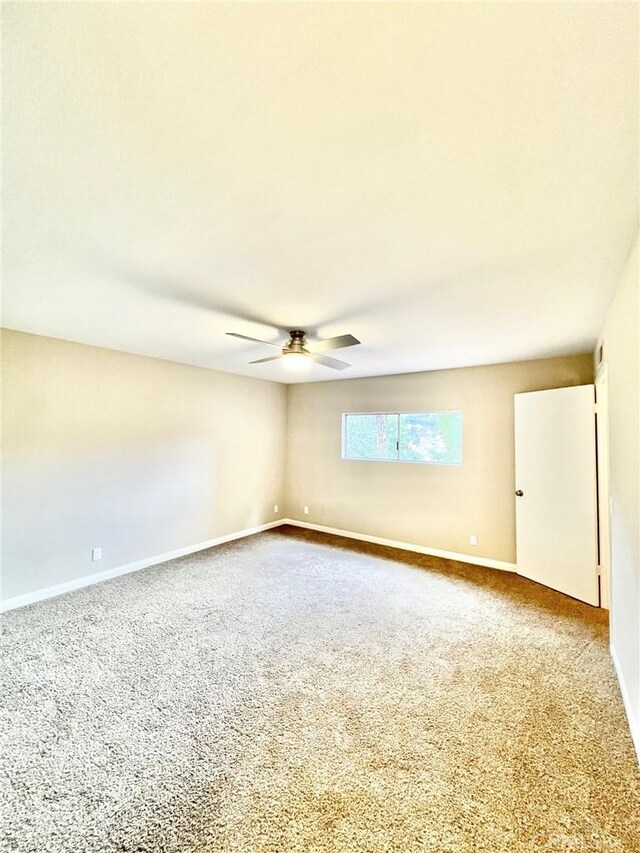 carpeted spare room with ceiling fan