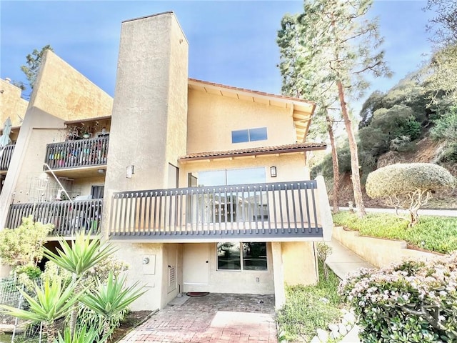 rear view of property featuring stucco siding