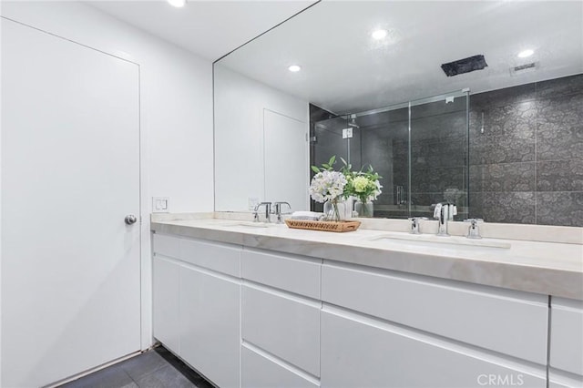 bathroom with walk in shower, vanity, and tile patterned flooring