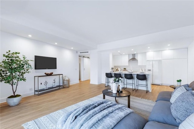 living room featuring light hardwood / wood-style floors and a barn door