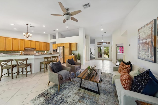 tiled living room featuring ceiling fan with notable chandelier, high vaulted ceiling, and french doors