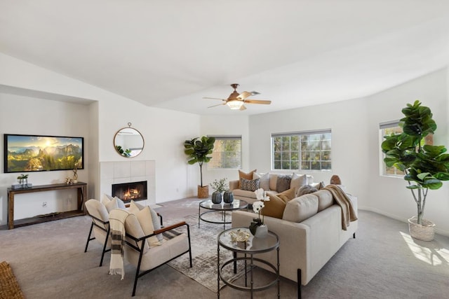 carpeted living room with ceiling fan and a fireplace