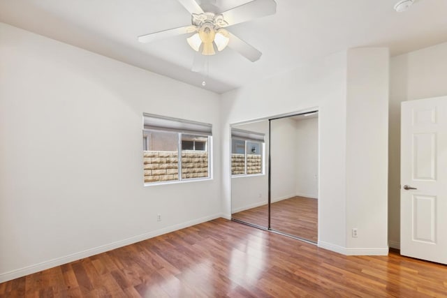 unfurnished bedroom featuring hardwood / wood-style flooring, a closet, and ceiling fan